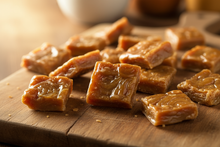 Load image into Gallery viewer, Buttered toffee on a wooden cutting board
